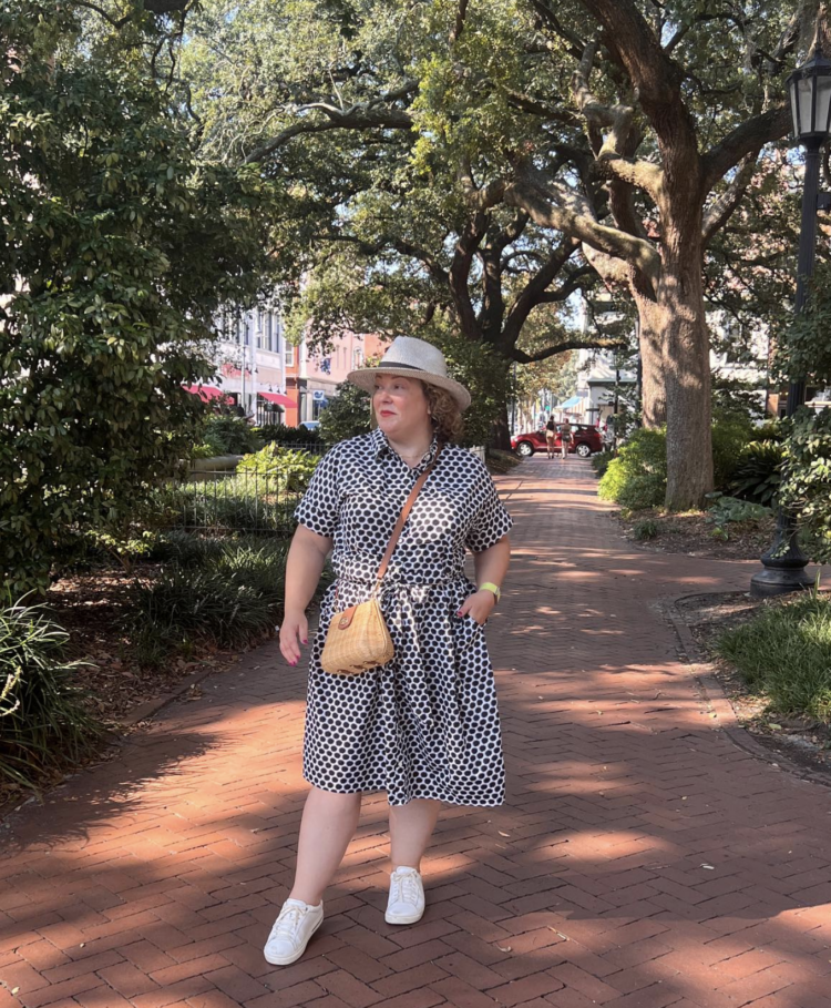 Alison in Savannah wearing a black and white cotton Talbots shirtdress with a straw hat, wicker crossbody bag, and white Birkenstock Bend sneakers